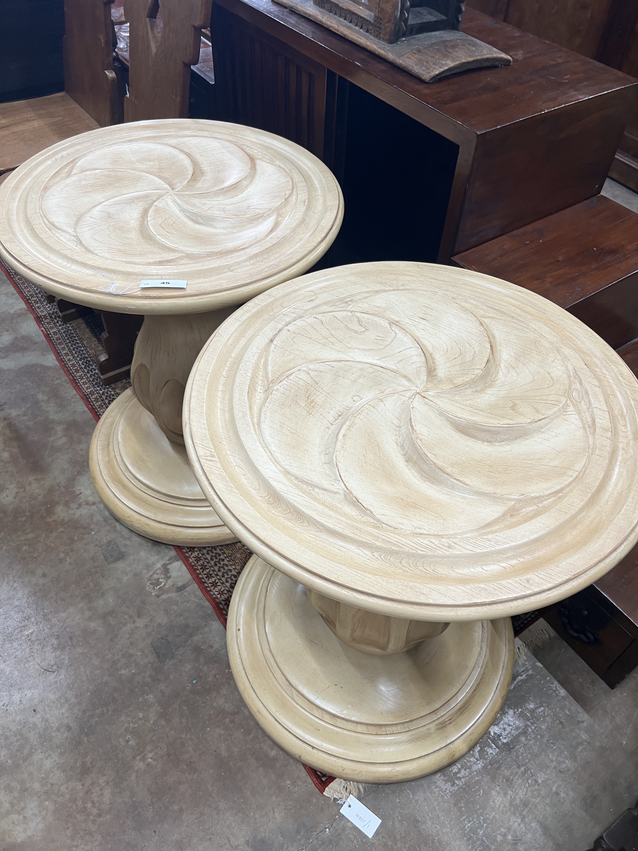 A pair of contemporary American circular carved wood centre tables, diameter 64cm, height 75cm
